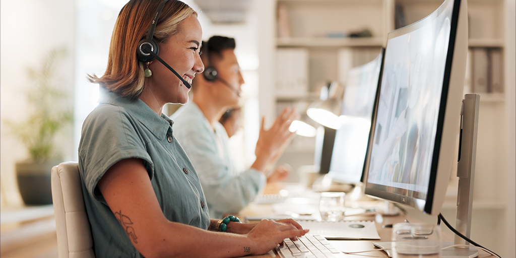 Female and male customer service agents sitting at their desk and speaking to the customers.