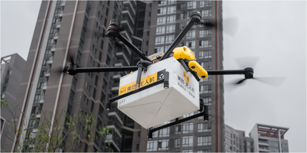 A drone in mid-air carrying a package.
