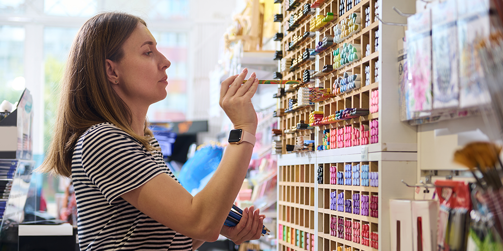 A woman standing in front of a shelf choosing an insence
