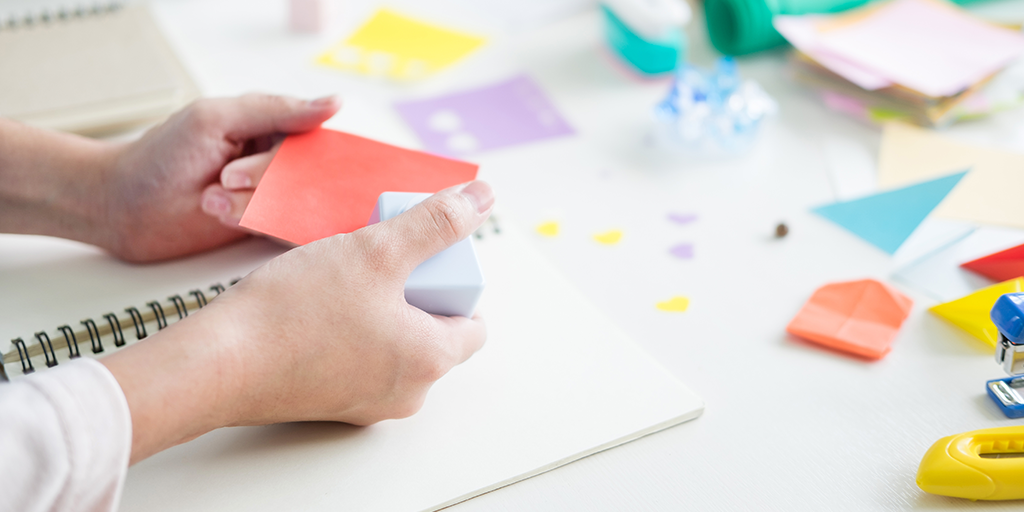 Woman holding a post-it note in her hands.