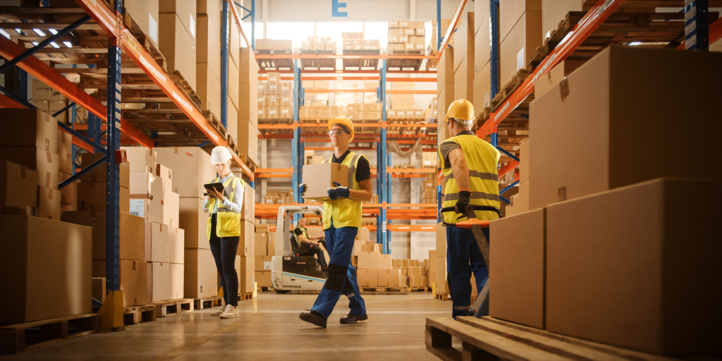 Workers carrying packages in a warehouse.